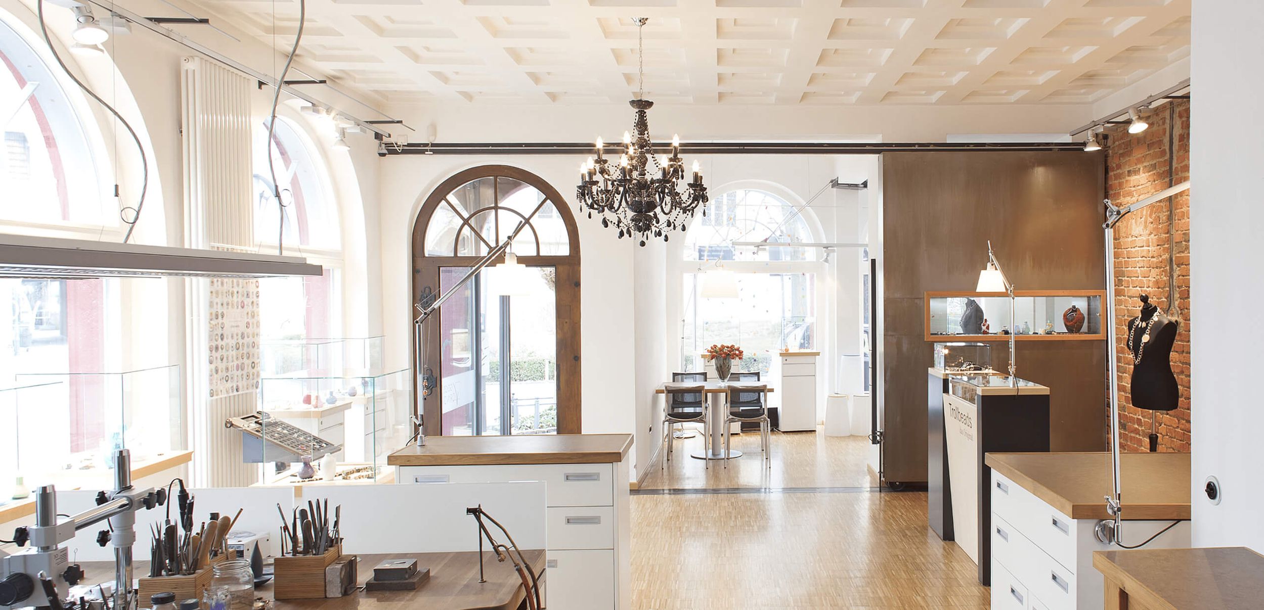 Innenansicht eines modernen Ateliers mit eleganter Einrichtung und einem Kronleuchter.